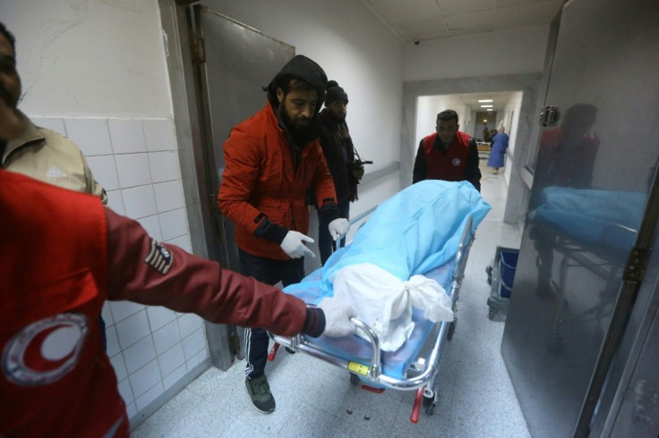 Emergency personnel pull a gurney with a victim on it from an air strike on a military school in the capital Tripoli