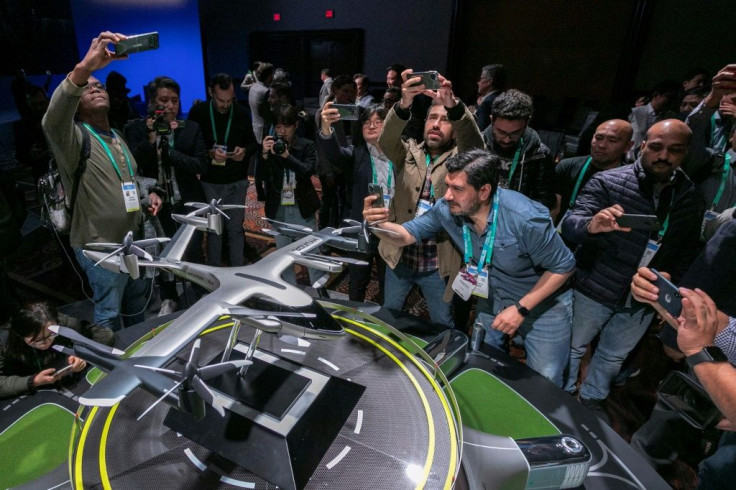 People take photos of a model of Hyundai's S-A1 electric vertical takeoff and landing (eVTOL) aircraft built in partnership with Uber to create an air taxi network, during the 2020 Consumer Electronics Show (CES) in Las Vegas