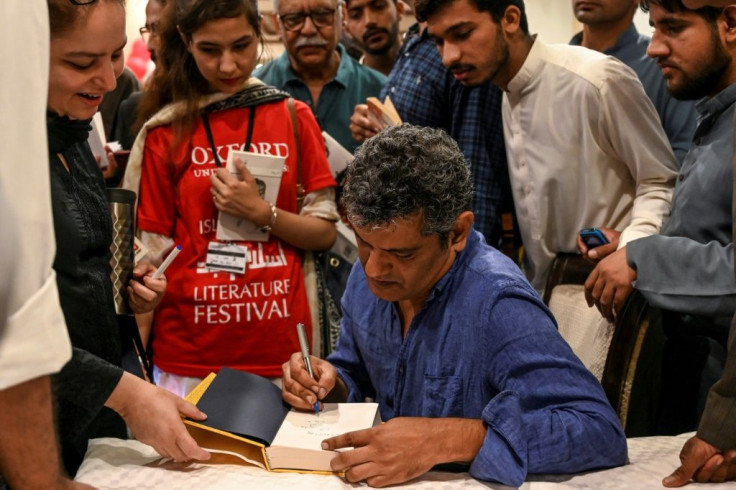 Author Mohammed Hanif signing copies of his book "A Case of Exploding Mangoes" in Islamabad in September 2019 after the release of its Urdu translationFeaturing bumbling generals, assassination plots, and homosexual romance, Pakistani military satire "A