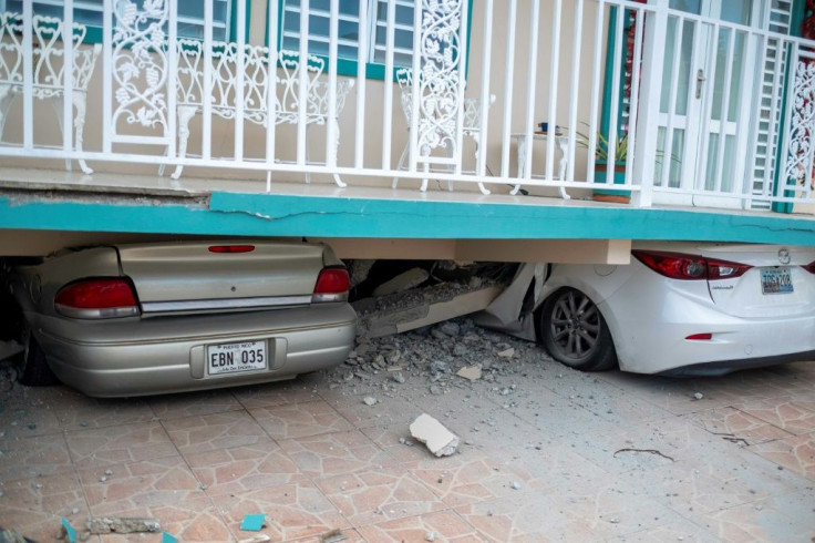 Cars are seen under a collapsed house damaged by an earthquake in Guanica, Puerto Rico on January 6