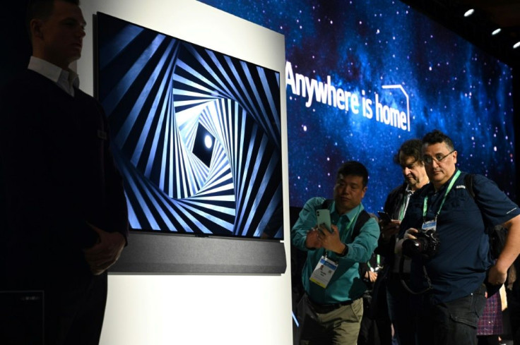 Attendees view the super thin LG GX series OLED 8K television at a press conference at CES in Las Vegas on January 6