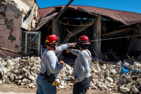 Two firemen survey a collapsed building after an earthquake hit Guanica, one of the towns which appeared to suffer the worst damage on Puerto Rico's southwest coast