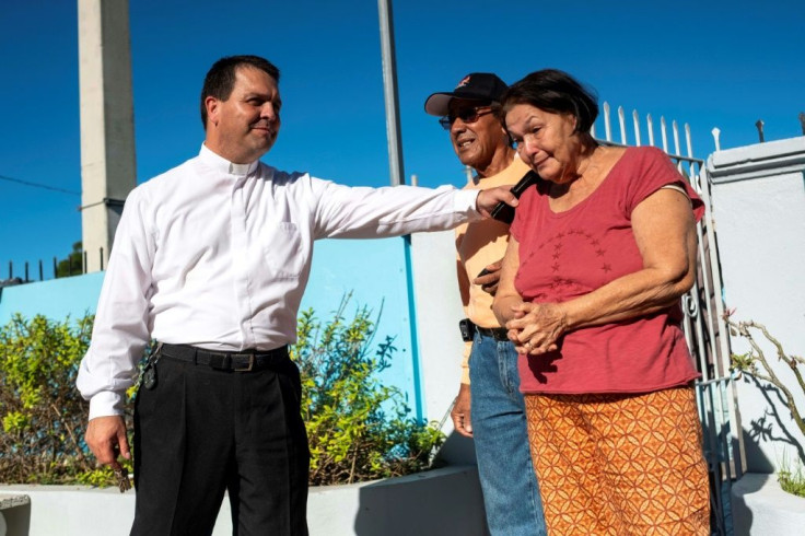 Father Melvin Diaz from the Inmaculada Concepcion church comforts a woman outside the church which collapsed during the earthquake in Guayanilla, Puerto Rico