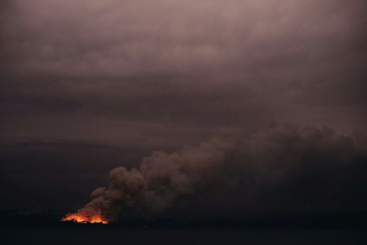 This handout photo taken on January 6, 2020 and received on January 7 from the Australian Department of Defence shows a fire in the distance seen from the Royal Australian Navy's HMAS Adelaide ship off the coast in Eden in New South Wales