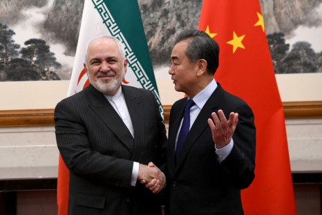 China's Foreign Minister Wang Yi shakes hands with his Iranian counterpart Mohammad Javad Zarif during their meeting in Beijing in December 2019
