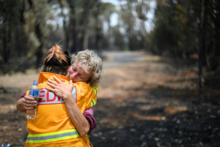 Orchard owner Stephenie Bailey hugs an AFP reporter after being overcome with emotion on her farm in Batlow, New South Wales