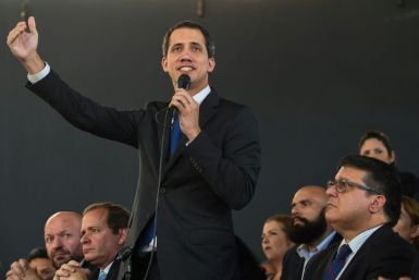 Venezuelan opposition leader Juan Guaido addresses a news conference, flanked by opposition lawmakers and supporters, after being sworn in for a new term as National Assembly leader