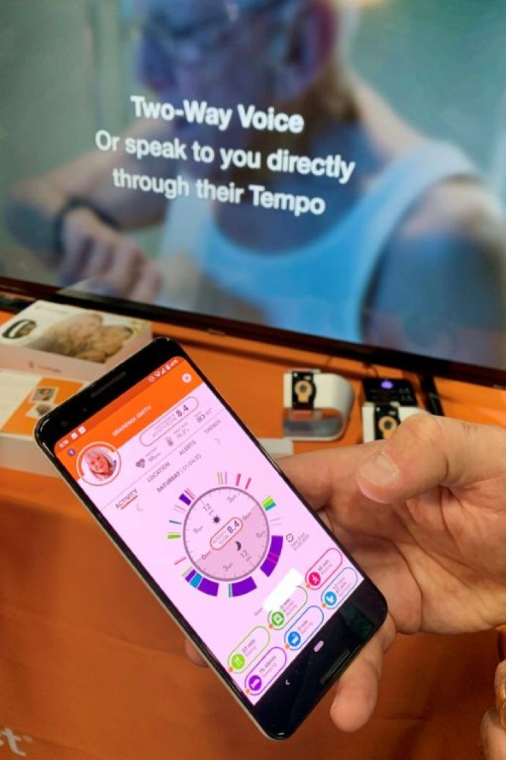 A person holds up the CarePredict app, which monitors seniors' daily activity and behavior patterns and alerts caregivers in case of changes that could indicate falls, malnutrition or depression at the 2020 Consumer Electronics Show