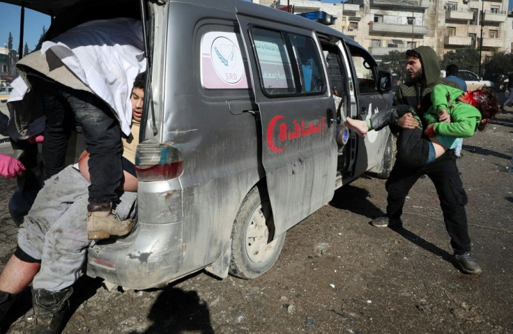 Casualties are loaded into an ambulance following an air strike by pro-regime forces in the nothwestern Syrian city of Idlib on Saturday