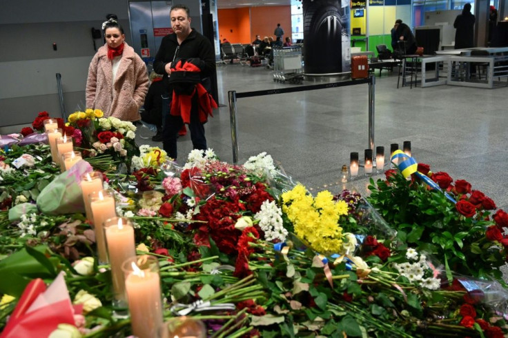 People stand in front of a makeshift memorial at the Boryspil airport outside Kiev, on Saturday