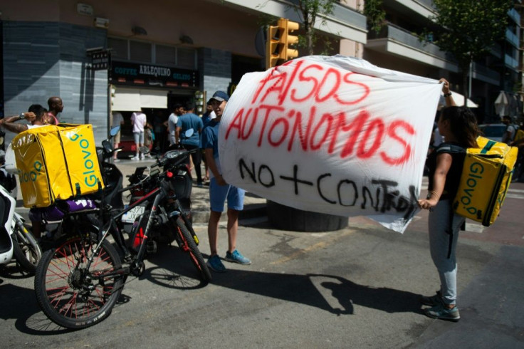 Glovo riders hold a banner reading 'Fake self-employed, no more control' during a strike in August 2019