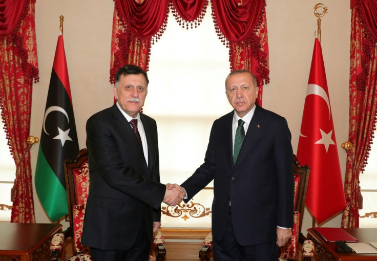 Turkey's President Recep Tayyip Erdogan (R) shakes hand with the head of Libya's Government of National Accord (GNA), Fayez al-Sarraj (L), at their meeting in Istanbul