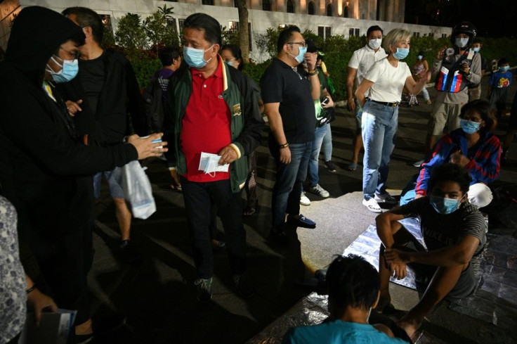 Ash from Taal volcano reached Manila, where local officials (L) talked to homeless people and distributed face masks for protection