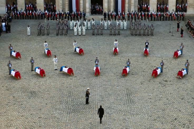 France's President Emmanuel Macron stands in front of the coffins of 13 French soldiers killed in action in Mali last November