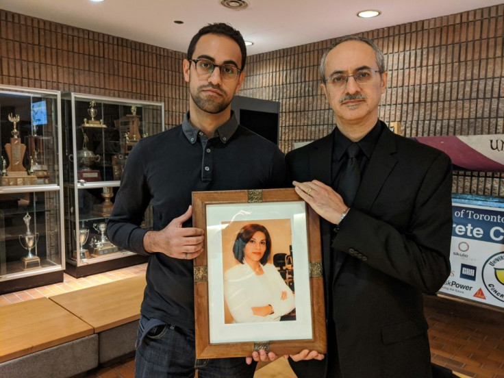 Amirali Alavi (L) holds a picture of his mother Neda Sadighi, one of the victims of Ukrainian Airlines flight 752, with his father Farzad Alavi (R) at his side on January 12, 2020 at the University of Toronto, Canada
