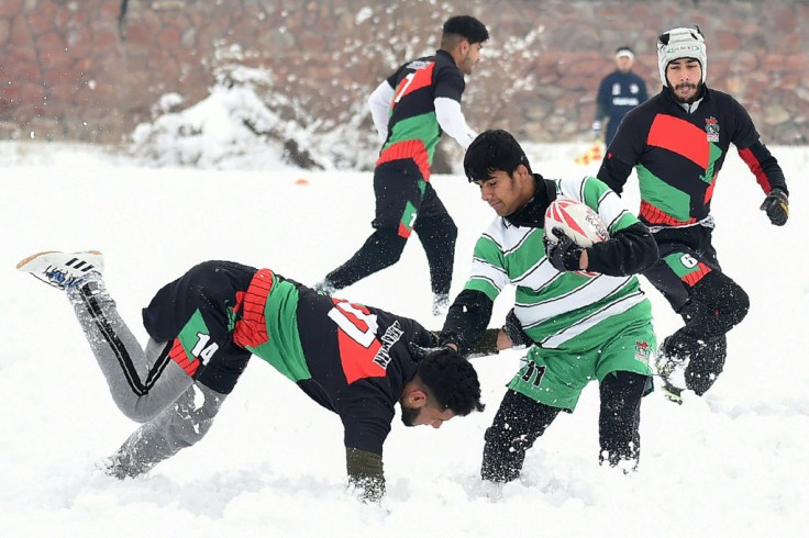Afghan men enjoy a game of rugby in the snow in the capital, Kabul