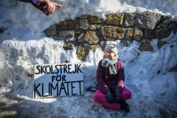 Swedish youth climate activist Greta Thunberg, seen here at the 2019 World Economic Forum sitting next to a placard reading "school strike for climate", will also be at the event this year