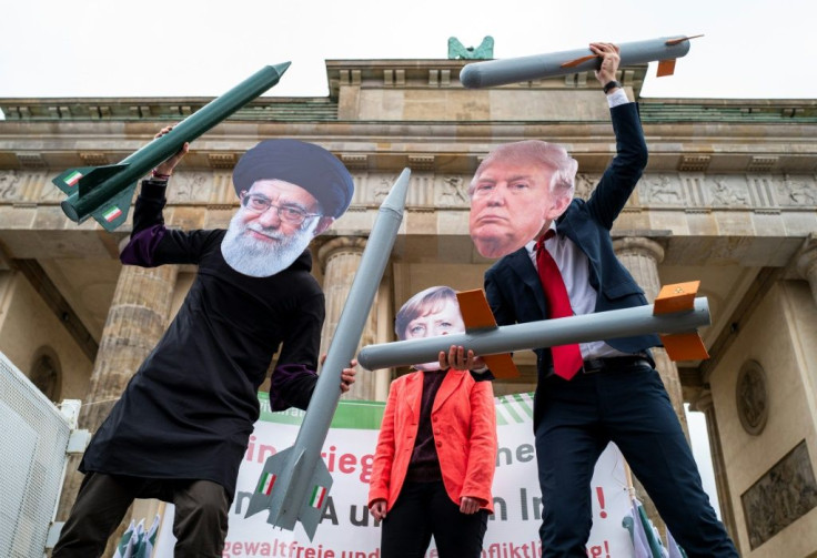 Protesters wearing masks of Iran's Supreme Leader Ali Khamenei, German Chancellor Angela Merkel and US President Donald Trump perform during an anti-war demonstration in front of Berlin's Brandenburg Gate in January 2020