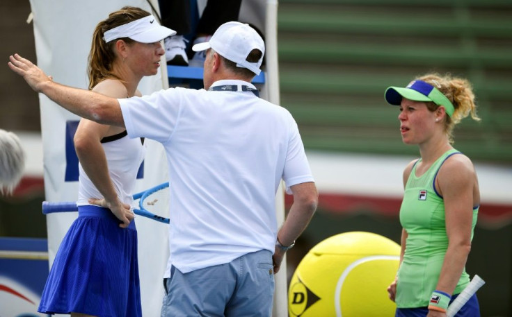 Maria Sharapova (left) and Laura Siegemund speak to a Kooyong Classic official before their match was abandoned in smoke haze on Tuesday