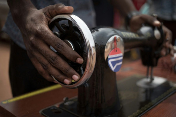 A former child soldier receives a sewing machine to help set up a business after finishing training as a tailor