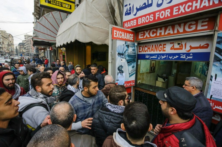 Lebanese anti-government protesters gather at the entrance of a currency exchange bureau in the northern port city of Tripoli