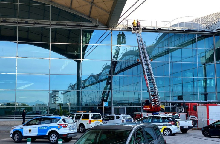 Firefighters work at the airport in Alicante after a fire led to the cancellation of 10 flights