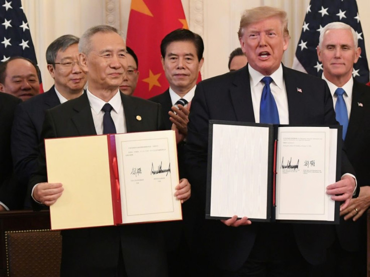 Chinese Vice Premier Liu He and President Donald Trump display the trade agreement signed between the United States and China