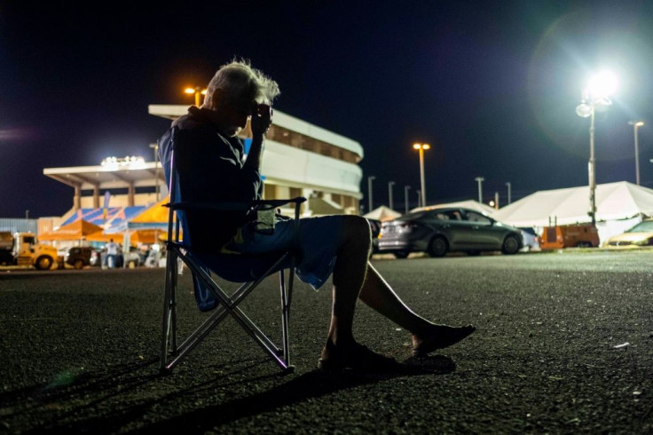 A man sits on a camping chair at a tent city shelter in a baseball stadium parking lot in Yauco, Puerto Rico on January 14, 2020, after a powerful earthquake hit the island