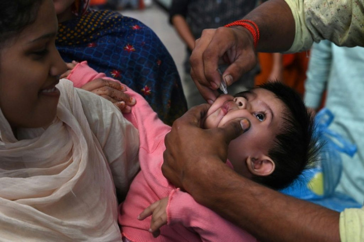 A Pakistani health worker administers polio drops to a child at a railway station during a polio vaccination campaign in Lahore in November 2019
