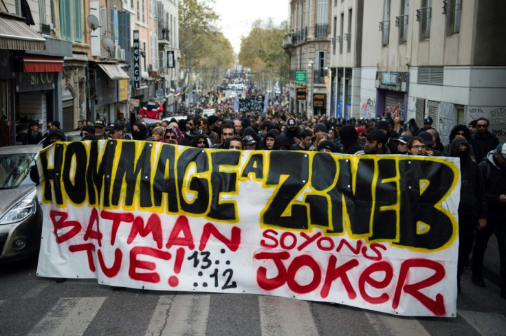 Protestors hold a banner reading "Tribute to Zineb. Batman kills, let's be the Joker" during a march in tribute to Zineb Redouane who died at the age of 80 in December 2018 after being hit by a police tear gas grenade