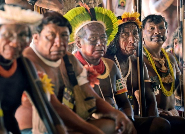 Indigenous tribesmen listen to chief Raoni Metuktire (out of frame) during a press conference in Piaracu village, near Sao Jose do Xingu, Mato Grosso state, Brazil