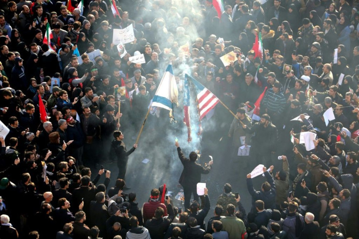 Iranians set a US and an Israeli flag on fire during a funeral procession for slain military commander Qasem Soleimani in Tehran on January 6