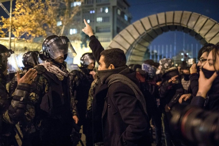 A man confronts riot police during a demonstration outside Tehran's Amir Kabir University after Iran admitted to having shot down a Ukrainian passenger jet by mistake