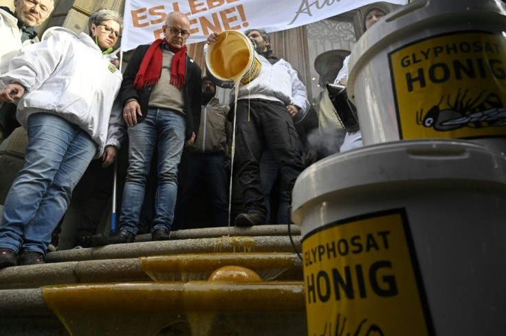 Beekeepers from the countryside outside Berlin dump buckets of honey on the steps of the Ministry for Agriculture
