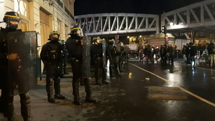 Dozens of protesters gather outside the Bouffes du Nord theatre in Paris where French President Emmanuel Macron attended a play. Demonstrations against a government plan to overhaul the pension system have roiled France for several weeks.