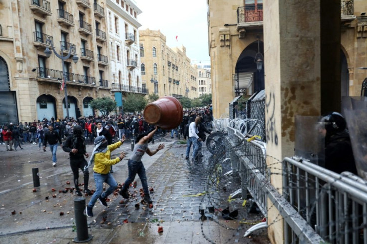 Anti-government protesters throw a large plant pot at Lebanese security forces in Beirut