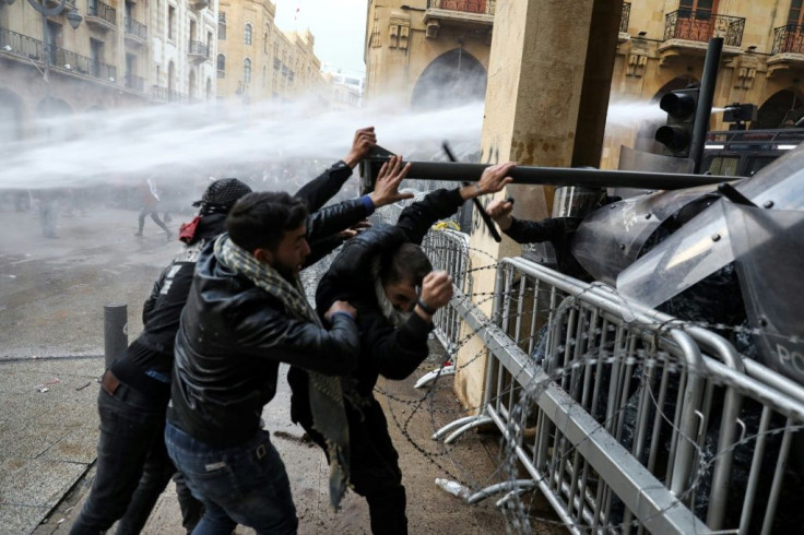 Anti-government protesters ram a road sign at Lebanese security forces taking in downtown Beirut