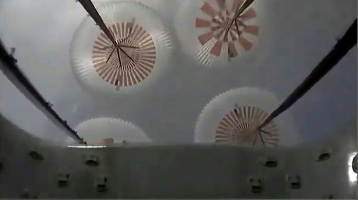 This NASA TV video frame grab shows four parachutes braking the descent of SpaceX Crew Dragon spacecraft before it splashes down in the Atlantic at the end of an emergency abort system test
