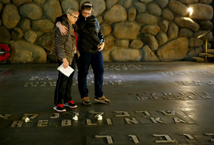 Israeli relatives of a Holocaust survivor stand at the Hall of Remembrance, where the names of major death and concentration camps are written, at the Yad Vashem Holocaust Memorial in Jerusalem