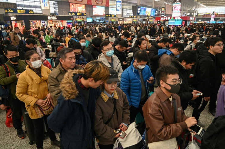 At Shanghai's Hongqiao Railway Station some travellers wear face masks as they wait to board their trains