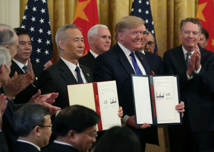 US President Donald Trump (pictured January 15, 2020) and Chinese Vice PremierÂ LiuÂ He hold up signed agreements of "phase one" of a trade deal between the two countries