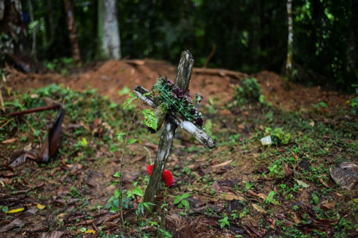 A cross has been placed at the sight of the mass grave where seven people -- six children and a pregnant woman -- were found buried