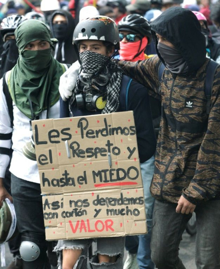 Anti-government protestors holding a sign reading "We lost respect for you and even our fear. We defend ourselves with cardboard and courage" during a protest in Bogota