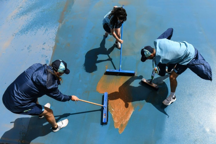 Workers had to clean the courts after they were left muddy from the rain