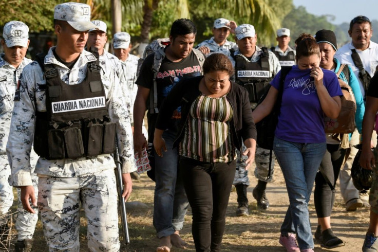 A Central American migrant family is escorted by members of the Mexican National Guard and officers of the Migration Institute after being detained crossing the Suchiate River, in Mexico