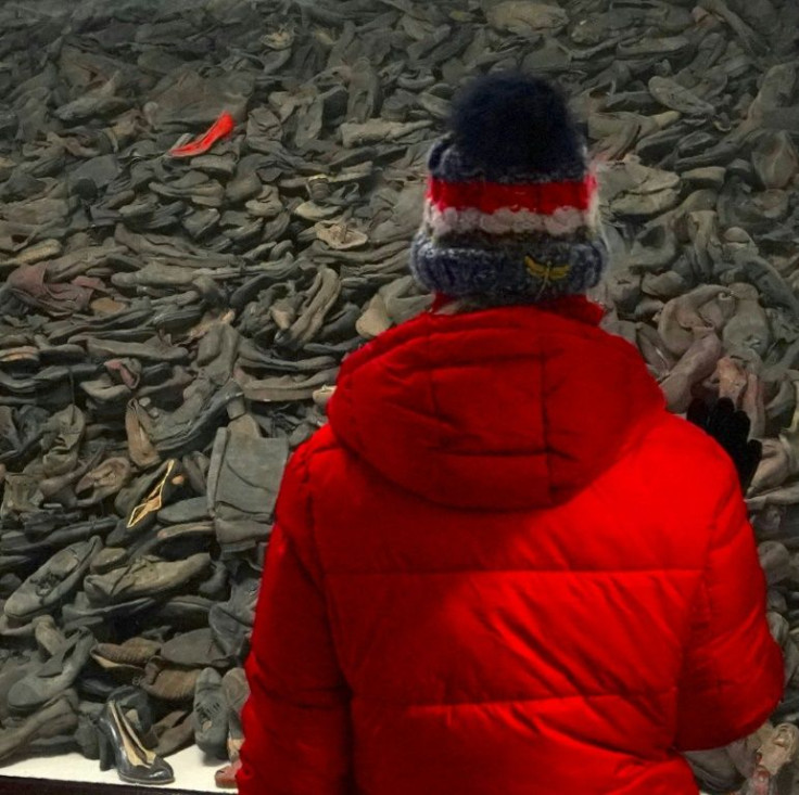 A visitor stands in front of a pile of victims' shoes at the Auschwitz death camp