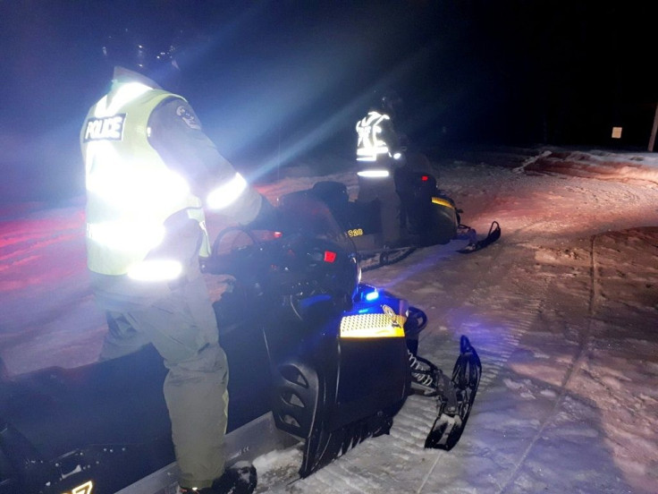 Police use snowmoblies during a search and rescue operations after a Canadian guide died and five French tourists went missing when their snowmobiles plunged through ice into the freezing water