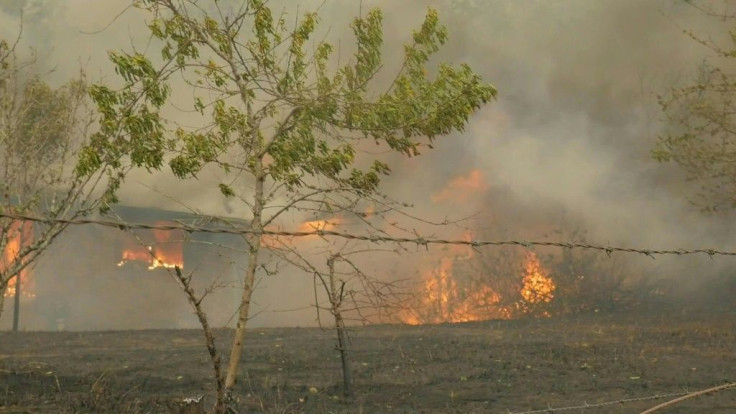 Australian firefighters tackle a house on fire near Moruya in New South Wales. High temperatures and strong winds have fuelled an outbreak of new blazes across several areas in eastern Australia, ending a period of respite