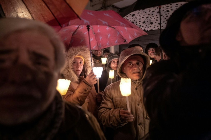 People hold torches and candles during a demonstration against anti-Semitism in Mondovi, northwestern Italy
