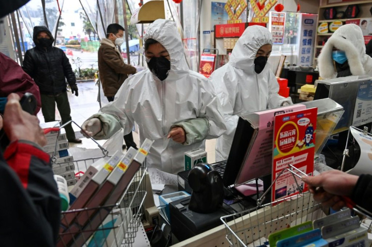 People in Wuhan are buying medical supplies in pharmacies where staff wear full body-suits, gloves and masks